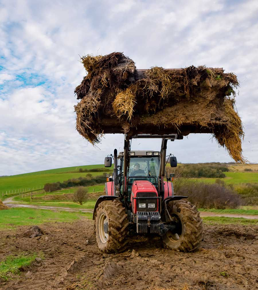 Traktor und seine Teleskopgabel, die den Dünger aufnehmen